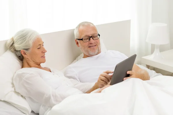 Šťastný starší pár s tablet pc doma — Stock fotografie