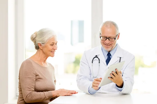 Femme âgée souriante et médecin avec comprimé pc — Photo