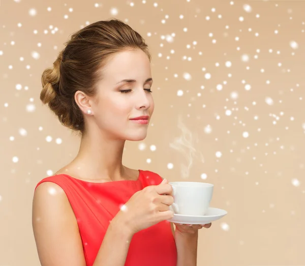 Mujer sonriente en vestido rojo con taza de café — Foto de Stock