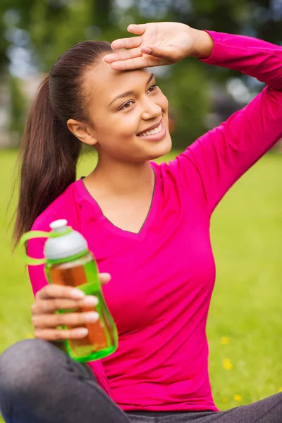 Sonriente adolescente mostrando botella — Foto de Stock