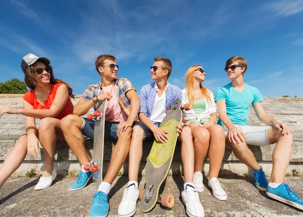 Gruppe lächelnder Freunde sitzt auf der Straße der Stadt — Stockfoto