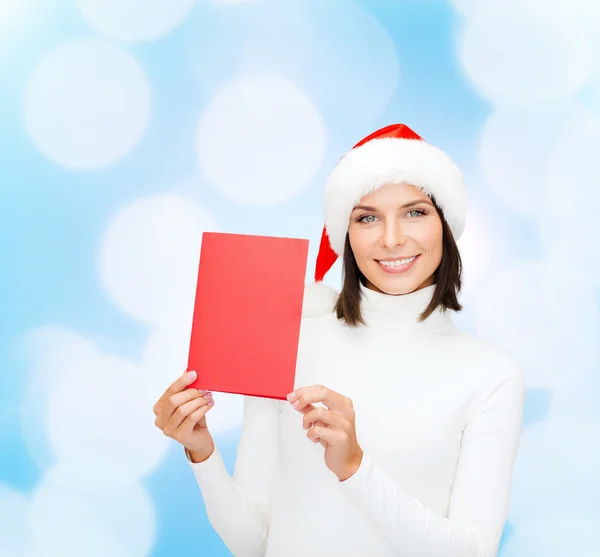 Femme souriante en chapeau de Père Noël avec carte de vœux — Photo