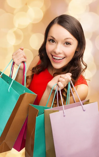 Mulher sorridente com sacos de compras coloridos — Fotografia de Stock