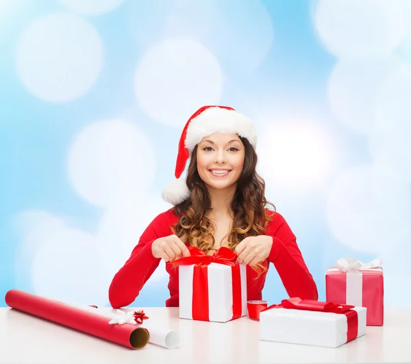 Santa yardımcı şapka hediye ambalaj içinde gülümseyen kadın — Stok fotoğraf