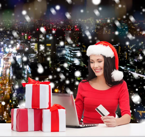 Mulher sorridente com presentes, laptop e cartão de crédito — Fotografia de Stock