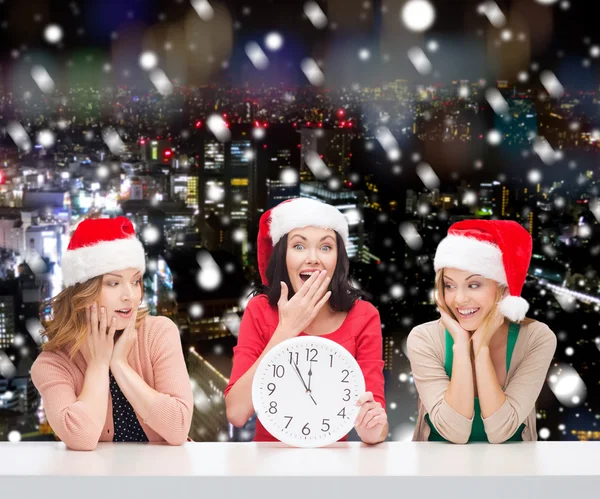 Santa yardımcı şapkalar saati ile gülümseyen kadın — Stok fotoğraf