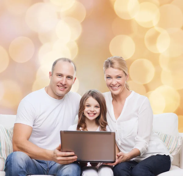 Familia sonriente con portátil — Foto de Stock