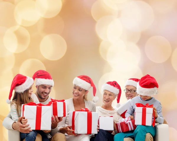 Família feliz em santa helper chapéus com caixas de presente — Fotografia de Stock