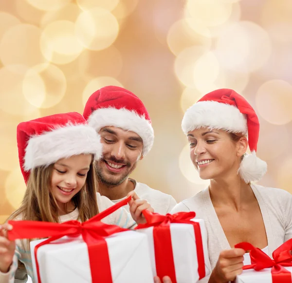 Familia feliz en sombreros de santa helper con cajas de regalo —  Fotos de Stock