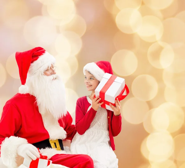 Noel Baba ve hediyeler ile gülümseyen küçük kız — Stok fotoğraf