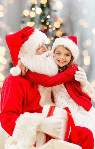 Lachende meisje met santa claus — Stockfoto