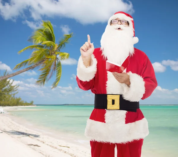 Man in costume of santa claus with notepad — Stock Photo, Image