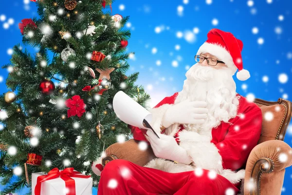 Man in costume of santa claus with notepad — Stock Photo, Image