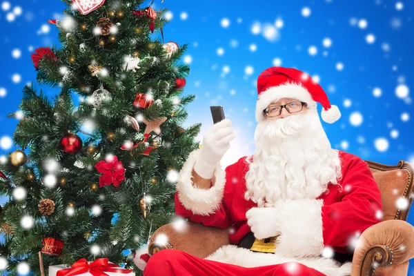 Santa Claus con smartphone y árbol de Navidad —  Fotos de Stock