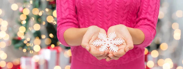 Close up de mulher em suéter segurando floco de neve — Fotografia de Stock