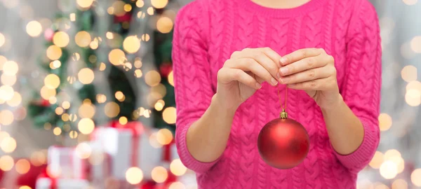 Primer plano de la mujer en suéter con bola de Navidad —  Fotos de Stock