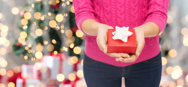 Close up of woman in pink sweater holding gift box — Stock Photo, Image