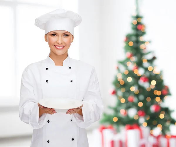 Chef feminino sorridente com prato vazio — Fotografia de Stock