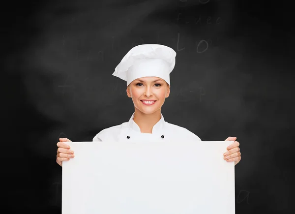 Chef feminino sorridente com placa branca em branco — Fotografia de Stock