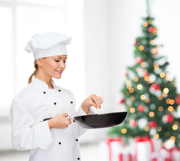 Cuoca sorridente con padella e cucchiaio — Foto Stock