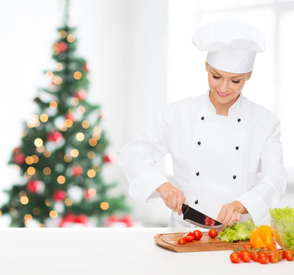 Glimlachend vrouwelijke chef-kok hakken groenten — Stockfoto