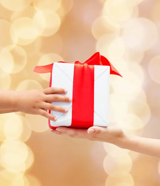 Close up of child and mother hands with gift box — Stock Photo, Image