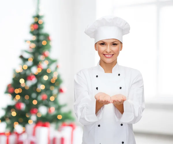 Sorrindo chef feminino segurando algo em mãos — Fotografia de Stock