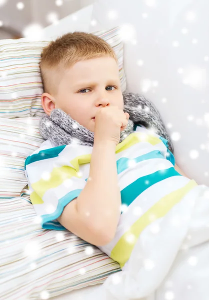 Kranker Junge mit Schal liegt im Bett und hustet — Stockfoto