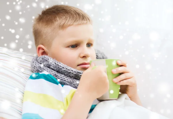 Malade garçon avec grippe au lit boire de tasse à la maison — Photo