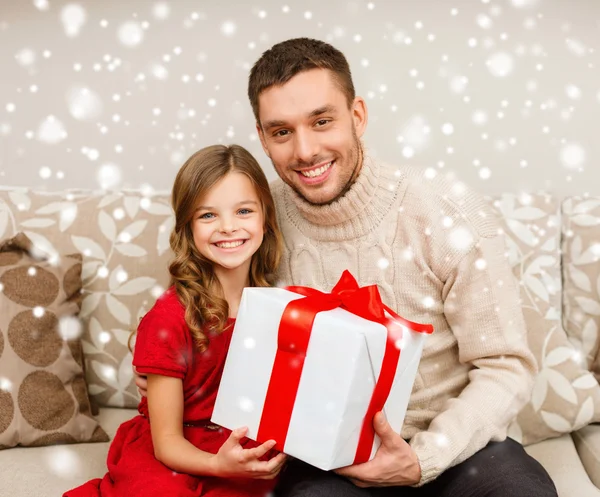 Leende far och dotter håller presentförpackning — Stockfoto