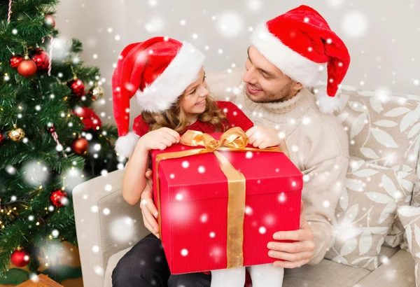 Leende far och dotter håller presentförpackning — Stockfoto