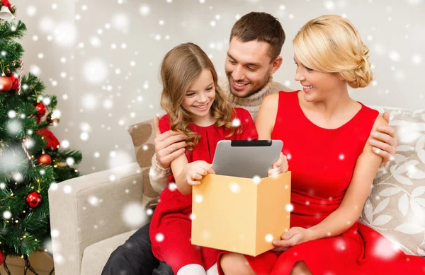 Familia sonriente tomando la tableta pc de la caja de regalo —  Fotos de Stock