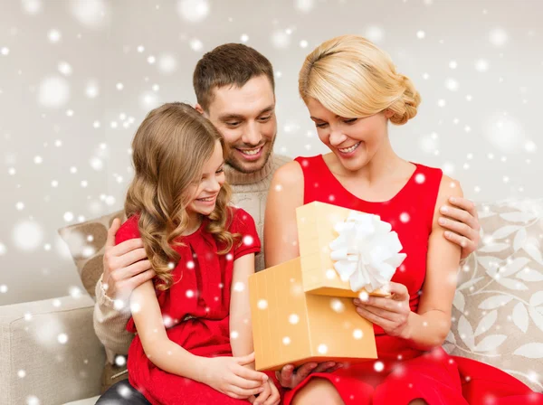 Sonriente familia sosteniendo caja de regalo — Foto de Stock