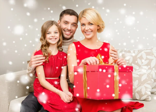 Sonriente familia sosteniendo caja de regalo — Foto de Stock