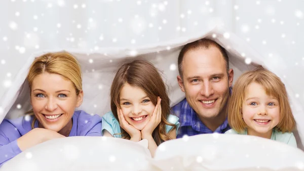 Happy family with two kids under blanket at home — Stock Photo, Image