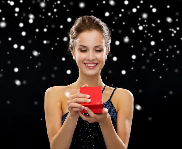 Smiling woman holding red gift box — Stock Photo, Image