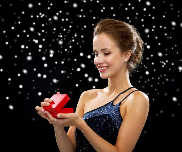 Femme souriante tenant boîte cadeau rouge — Photo