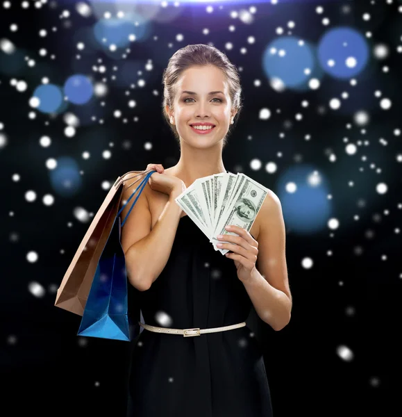 Mulher sorridente no vestido com sacos de compras — Fotografia de Stock