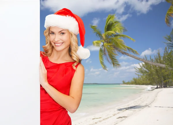 Lächelnde junge Frau mit Weihnachtsmütze und weißem Brett — Stockfoto