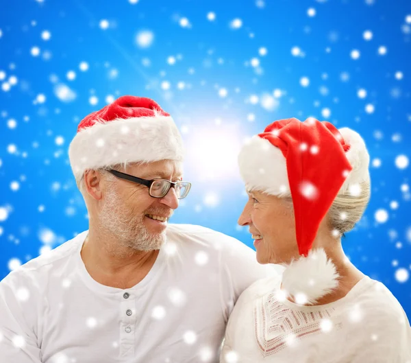 Happy senior couple in santa helper hats — Stock Photo, Image