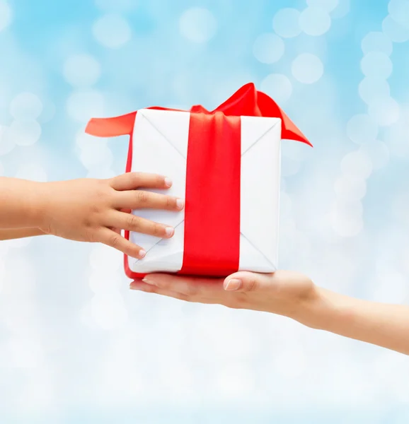 Close up of child and mother hands with gift box — Stock Photo, Image