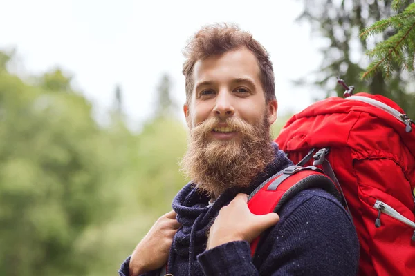 Homem sorridente com barba e mochila caminhadas — Fotografia de Stock