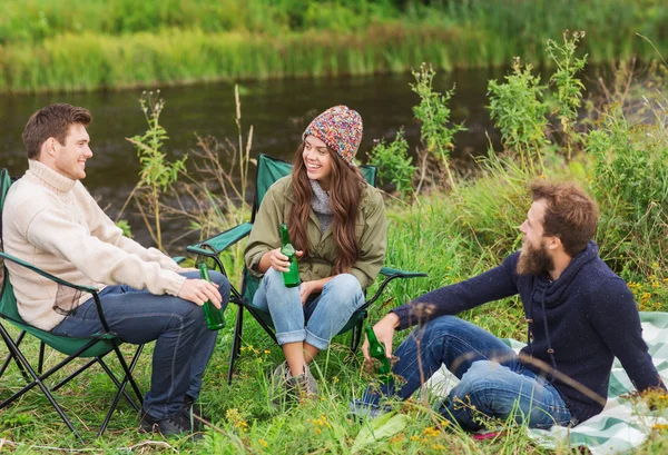 Group of smiling tourists drinking beer in camping — Stock Photo, Image