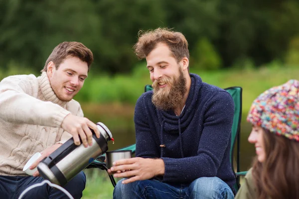 Group of smiling tourists cooking food in camping — Stock Photo, Image