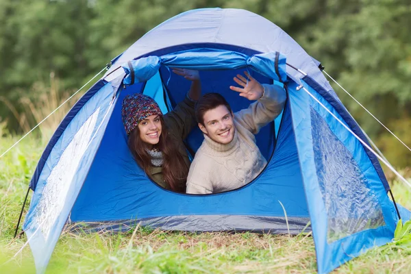 Coppia sorridente di turisti che guardano fuori dalla tenda — Foto Stock