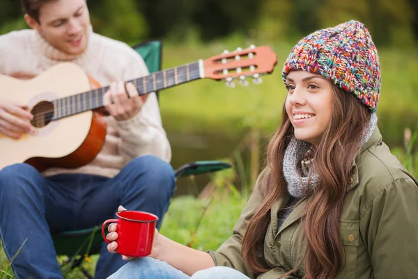 Улыбающаяся пара с гитарой в палатках — стоковое фото