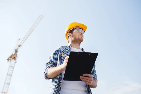 Stavitel v hardhat se schránkou venku — Stock fotografie