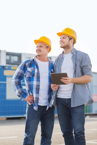 Costruttori sorridenti con tablet pc all'aperto — Foto Stock