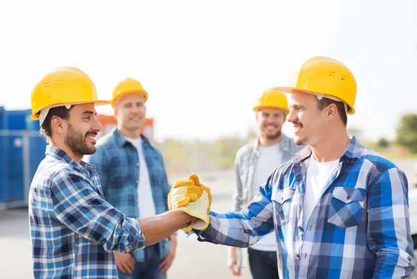 Gruppe lächelnder Bauarbeiter schüttelt Hände im Freien — Stockfoto