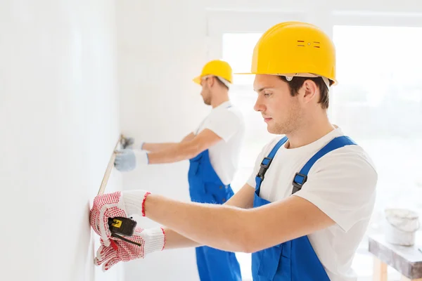 Grupo de constructores con cinta métrica en interiores — Foto de Stock